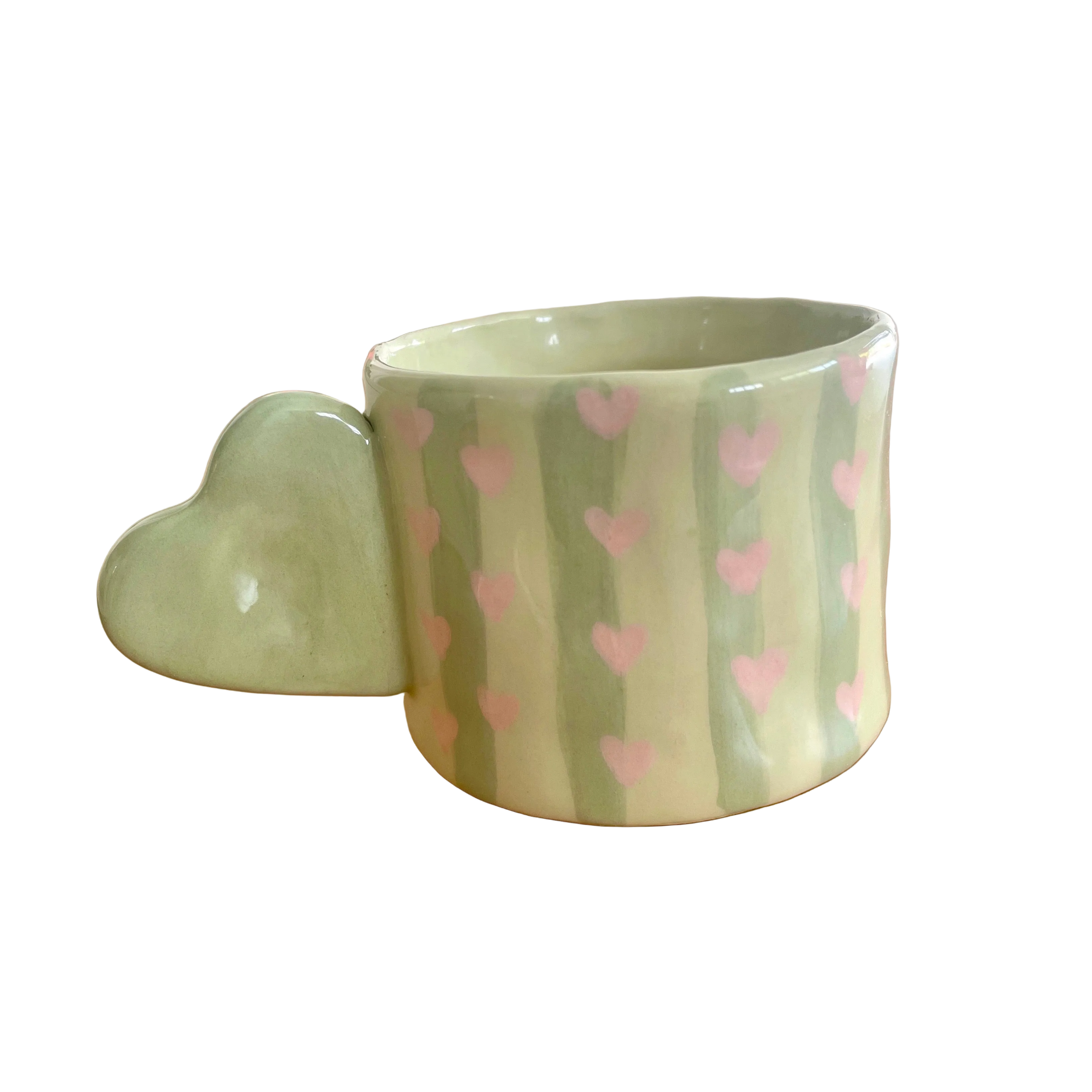 Taza de cerámica pintada a mano con asa de corazón, rayas verdes y corazones rosas.
