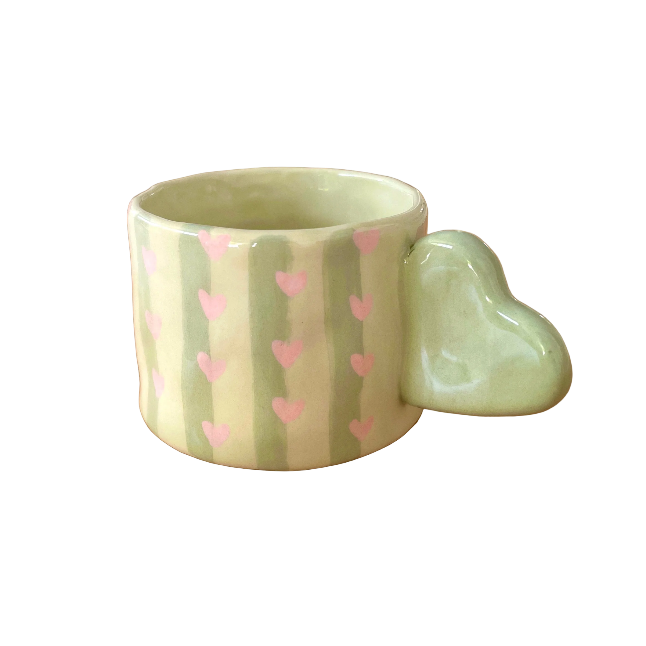 Taza de cerámica pintada a mano con asa de corazón, rayas verdes y pequeños corazones rosas.