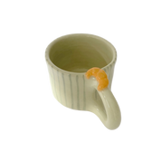 Taza de cerámica pintada a mano con rayas verdes y un croissant en relieve sobre el asa