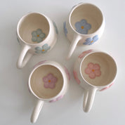 Tazas de cerámica hecha a mano con relieves de flores en azul, lila, rosa y verde de Pipa and Happy