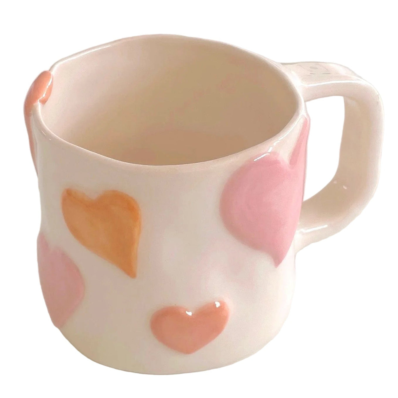 taza de cerámica con corazones en relieve pintados en tono rosa pastel
