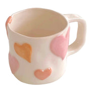 taza de cerámica con corazones en relieve pintados en tono rosa pastel
