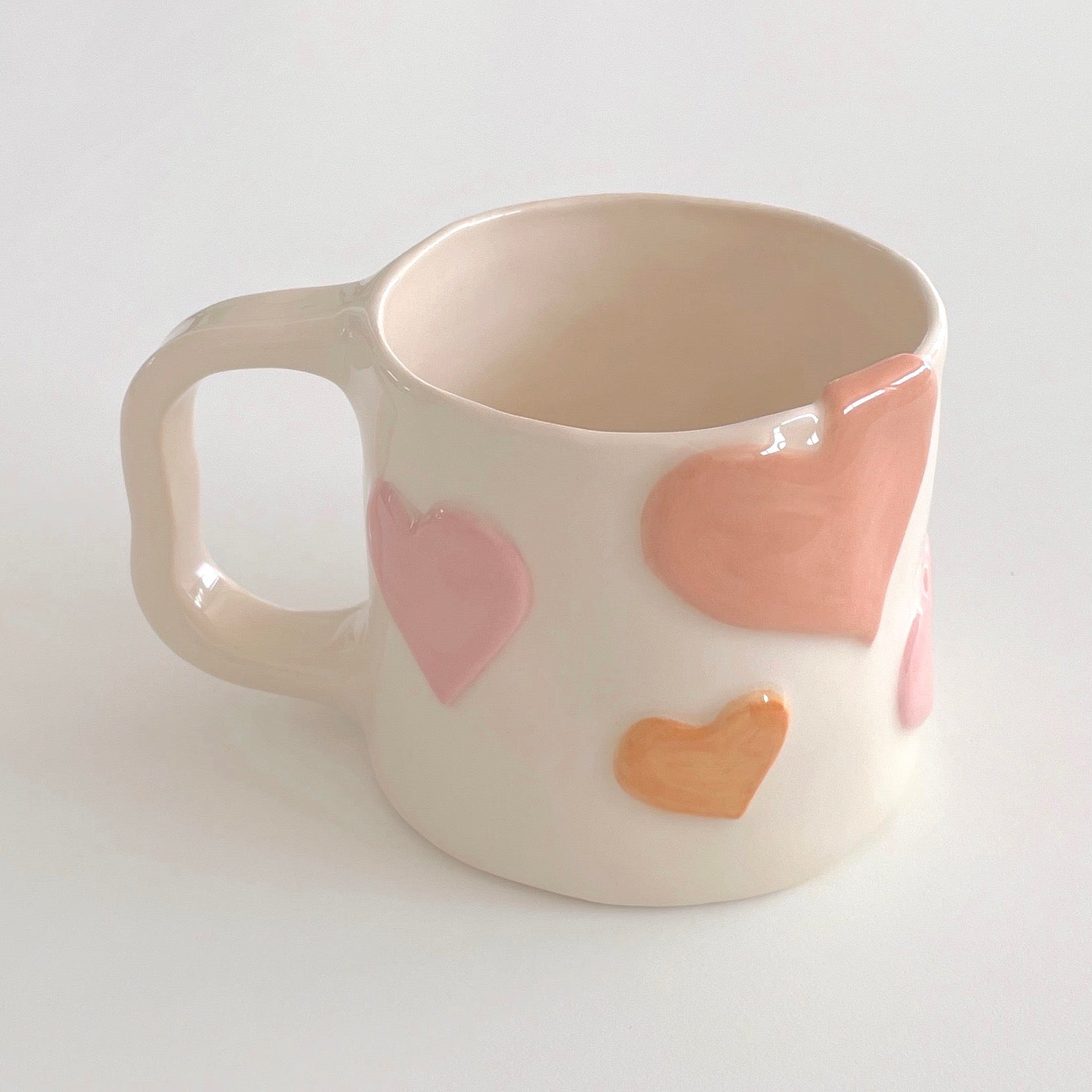 taza de cerámica hecha a mano con corazones rosas en relieve
