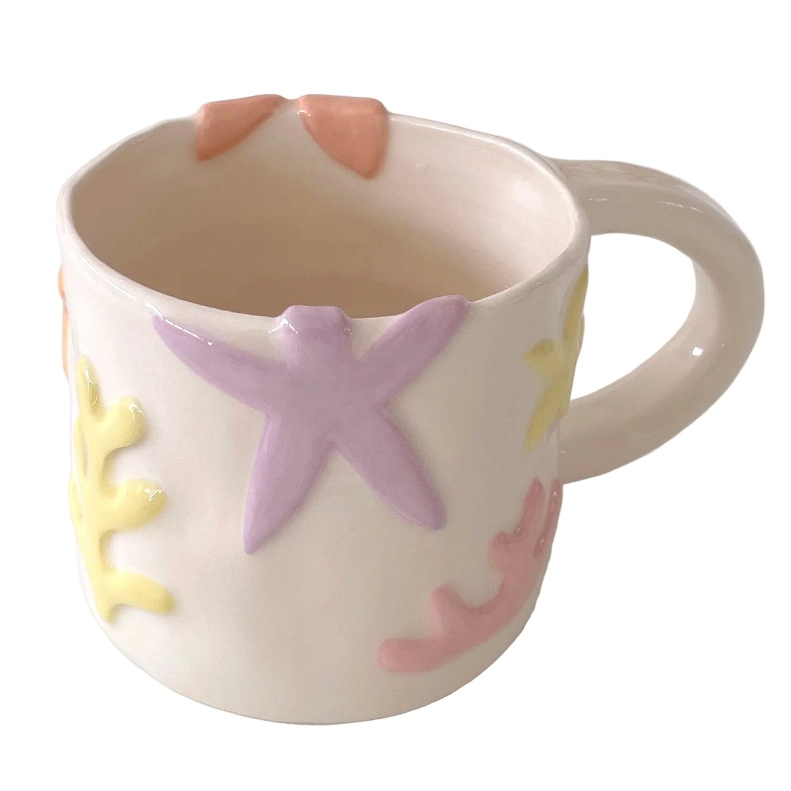 Taza de cerámica hecha a mano inspirada en el mar. Con relieves de estrellas, corales y formas orgánicas 