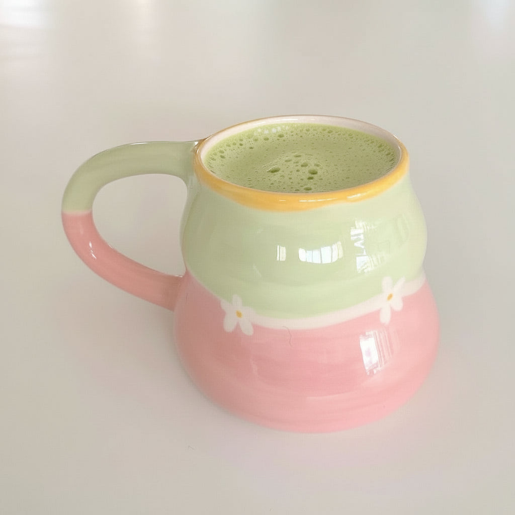 La taza Babi combina tonos verdes y rosas con pequeñas flores pintadas a mano. Su diseño suave la convierte en la pieza perfecta para tus momentos de matcha.