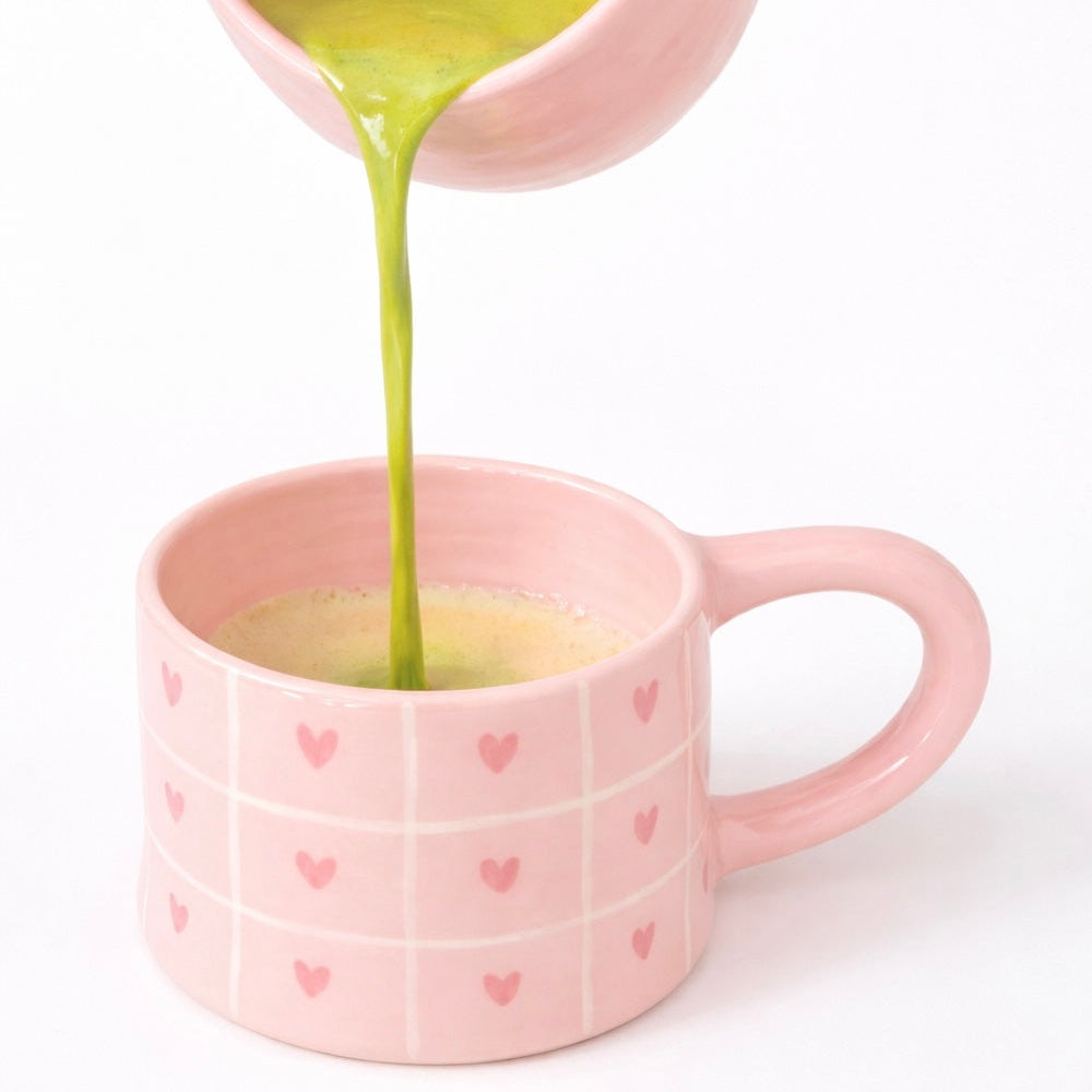 Taza de cerámica con rayas y corazones pintados a mano en color rosa pastel. Perfecta para cafés  y matcha latte