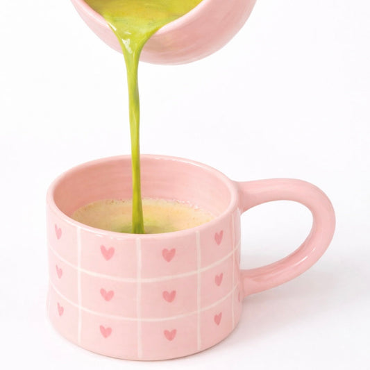 Taza de cerámica con rayas y corazones pintados a mano en color rosa pastel. Perfecta para cafés  y matcha latte
