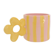 taza con asa de flor en amarillo rayas y fondo color rosa pastel 