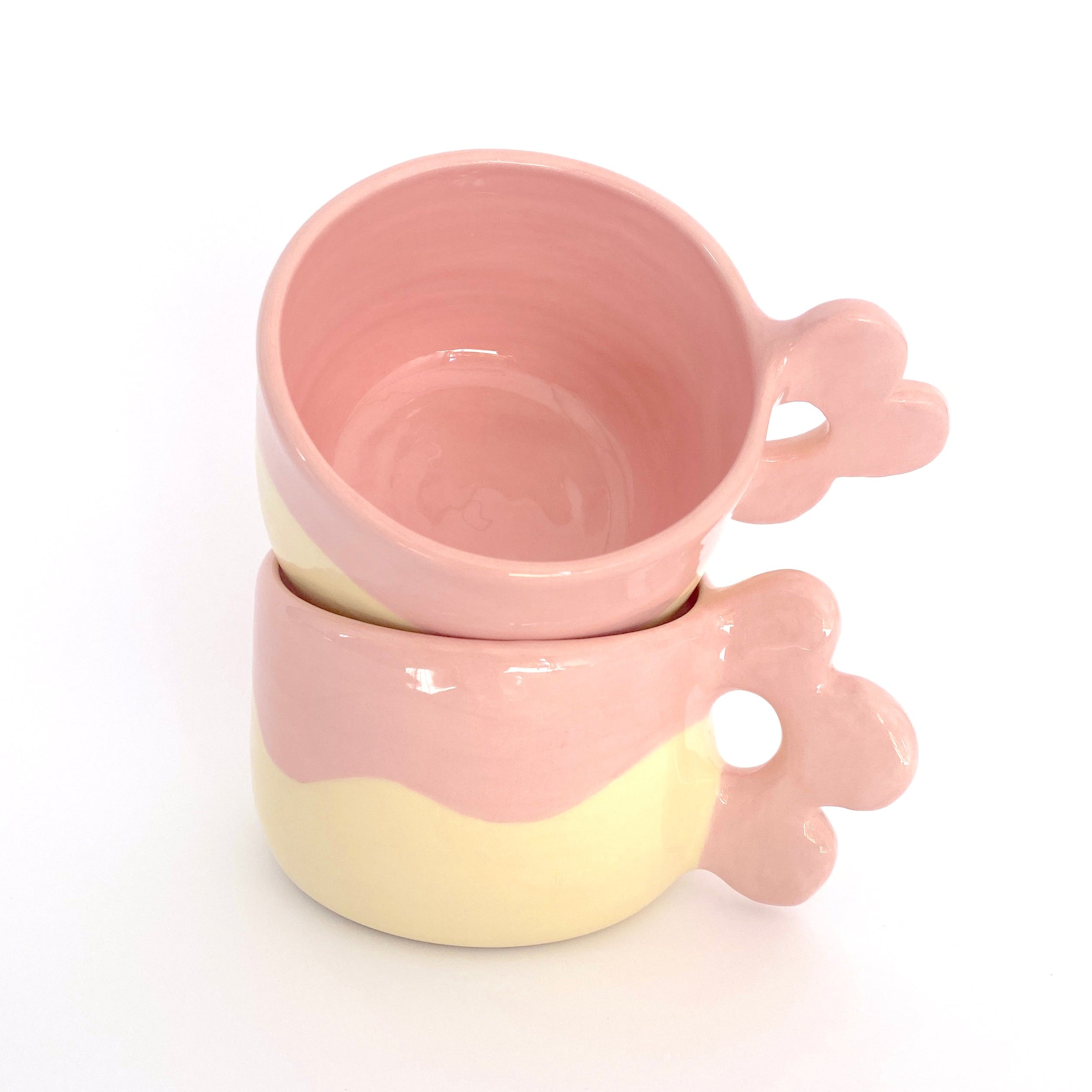 taza de cerámica con asa de flor en color rosa y amarillo pastel  