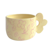 taza de ceramica de color amarillo pastel con flores pintadas y asa de flor de pipa and happy