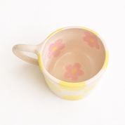 taza de ceramica con cuadros amarillos y flores rosas en el interior