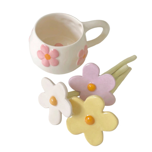 taza de cerámica para té y margaritas