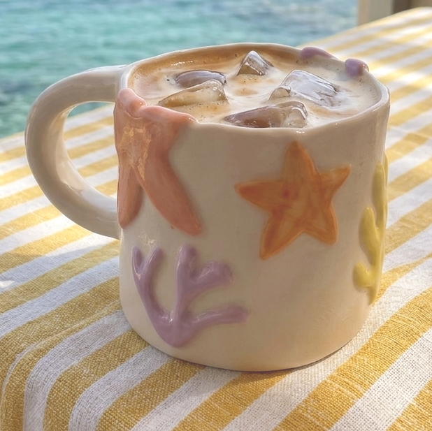 Taza de cerámica hecha a mano inspirada en el mar. Con relieves de estrellas, corales y formas orgánicas 
